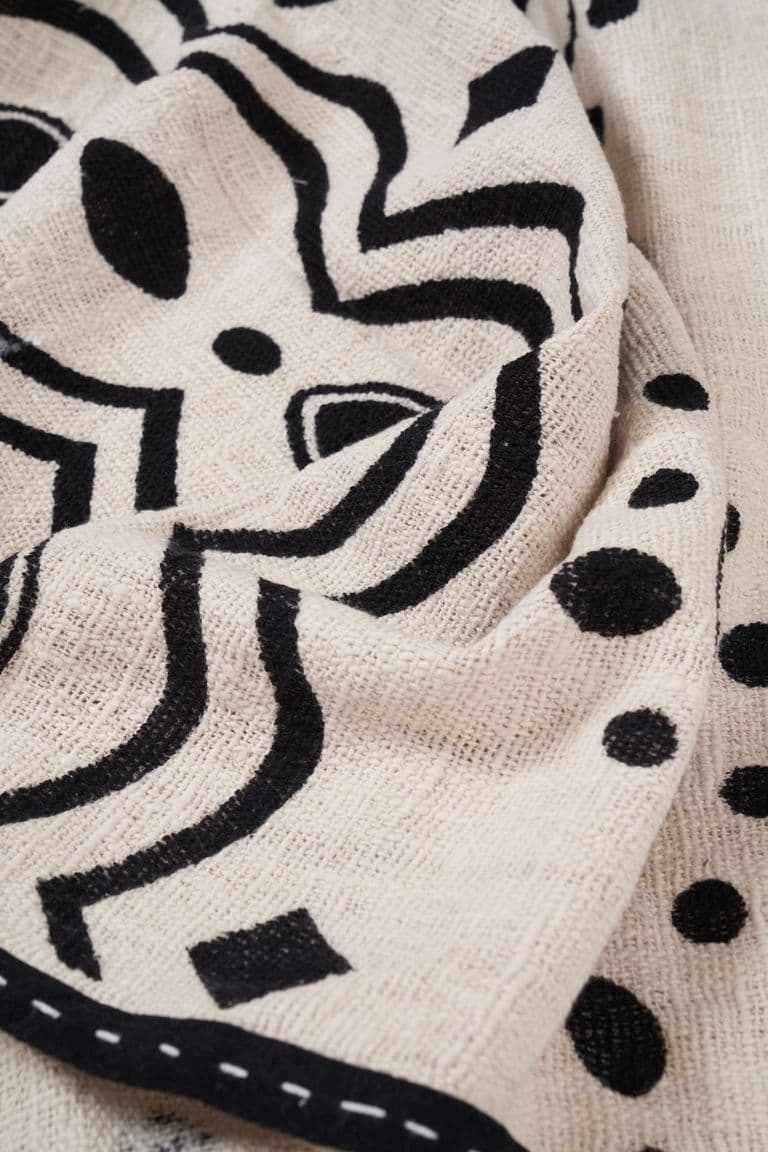 Cream KIND bedcover with a bold black print and a stitched black border