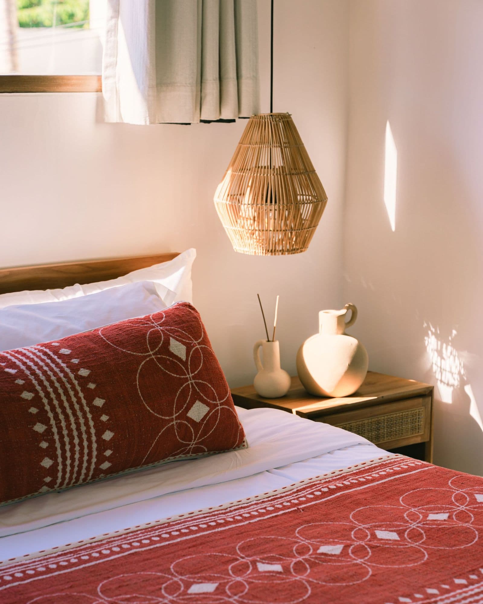 Sunlit bedroom with terracotta KIND bedcover and cushions