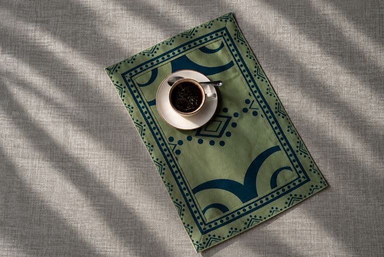 Cup of coffee on a green printed KIND placemat