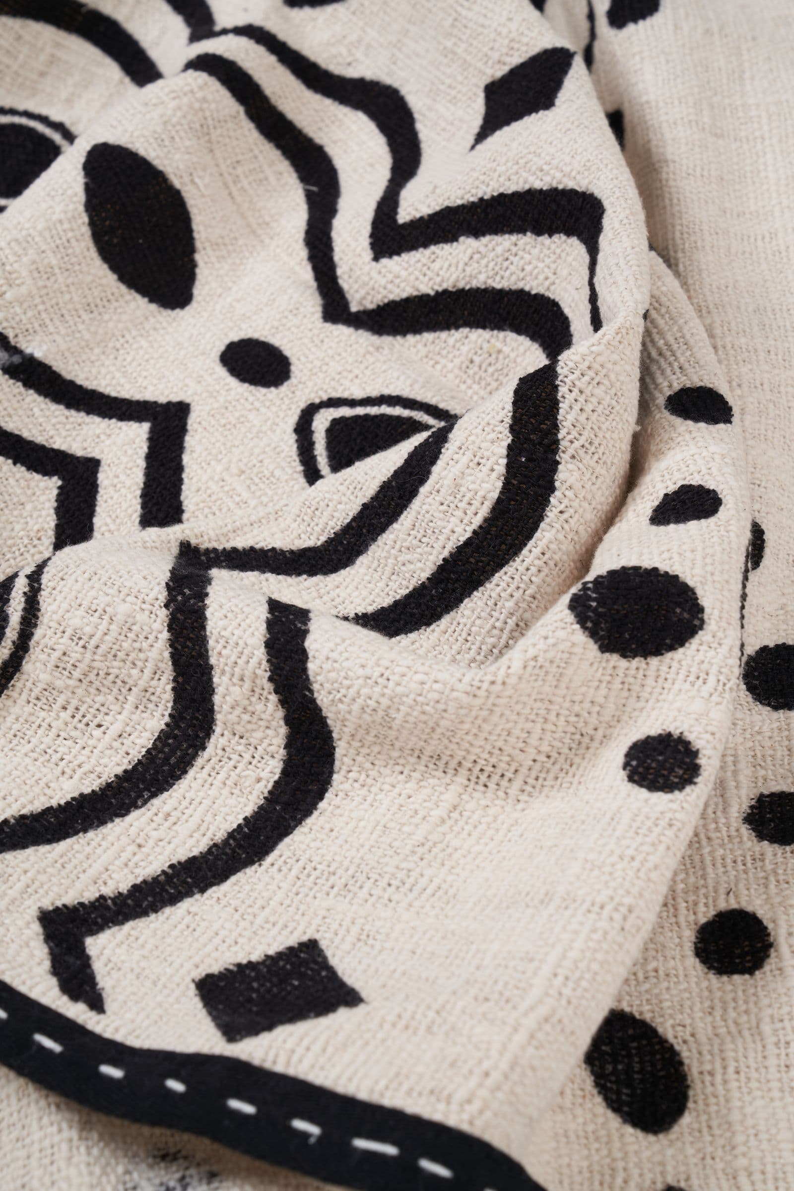 Cream KIND bedcover with a bold black print and a stitched black border